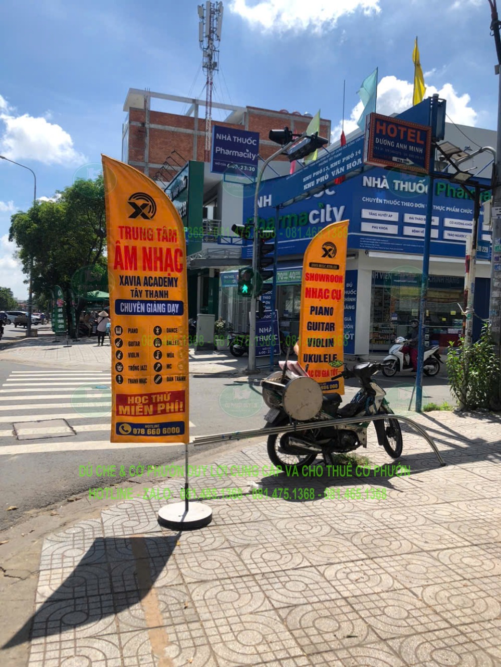 Cờ cánh buồm nền vàng với nhiều dòng thông tin được bố trí trên vỉa hè trước cửa hàng.