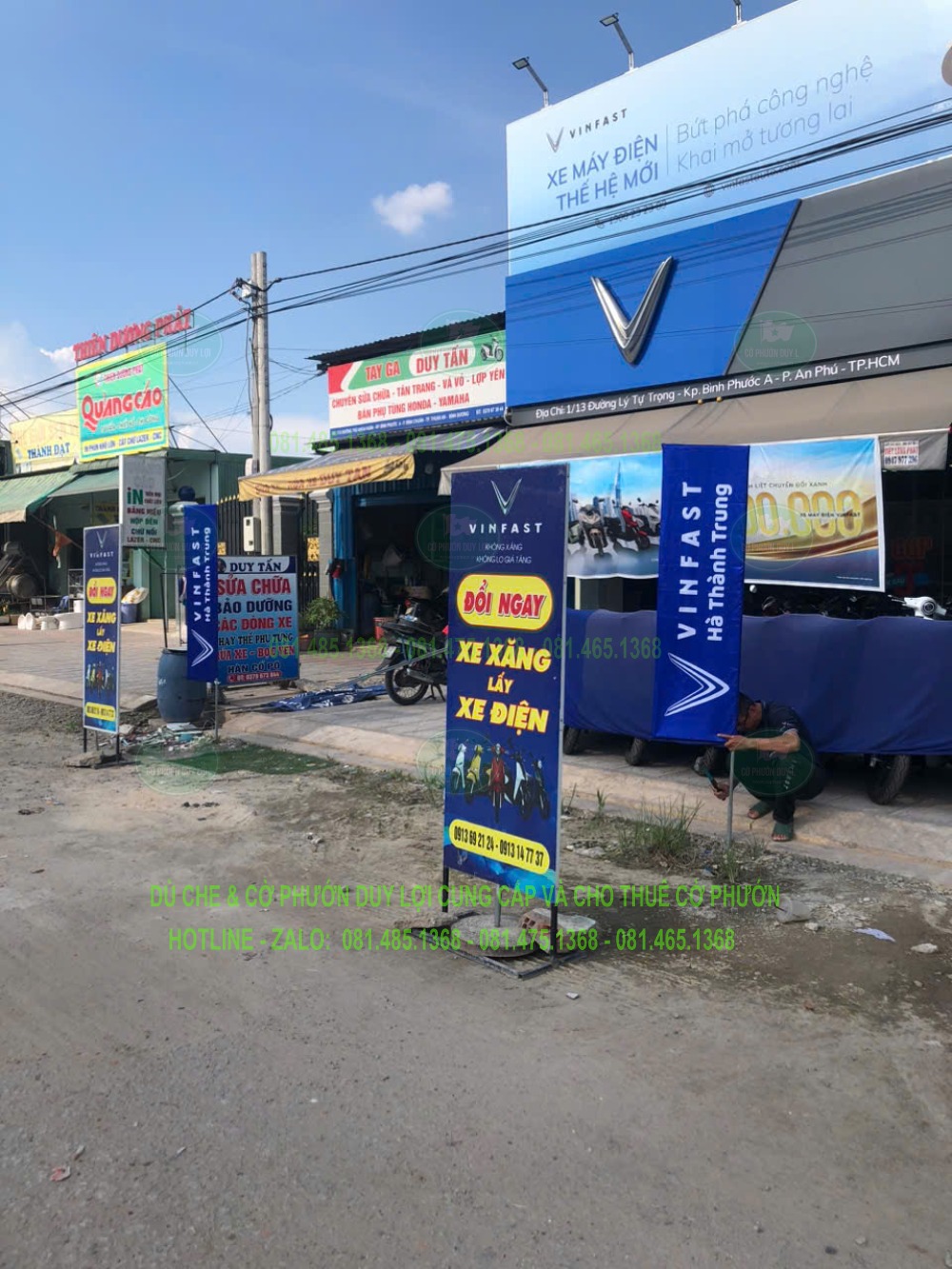 Cờ chữ nhật xanh–vàng mang nội dung đổi xe, đặt cùng các cờ nhận diện trước cửa hàng VinFast.