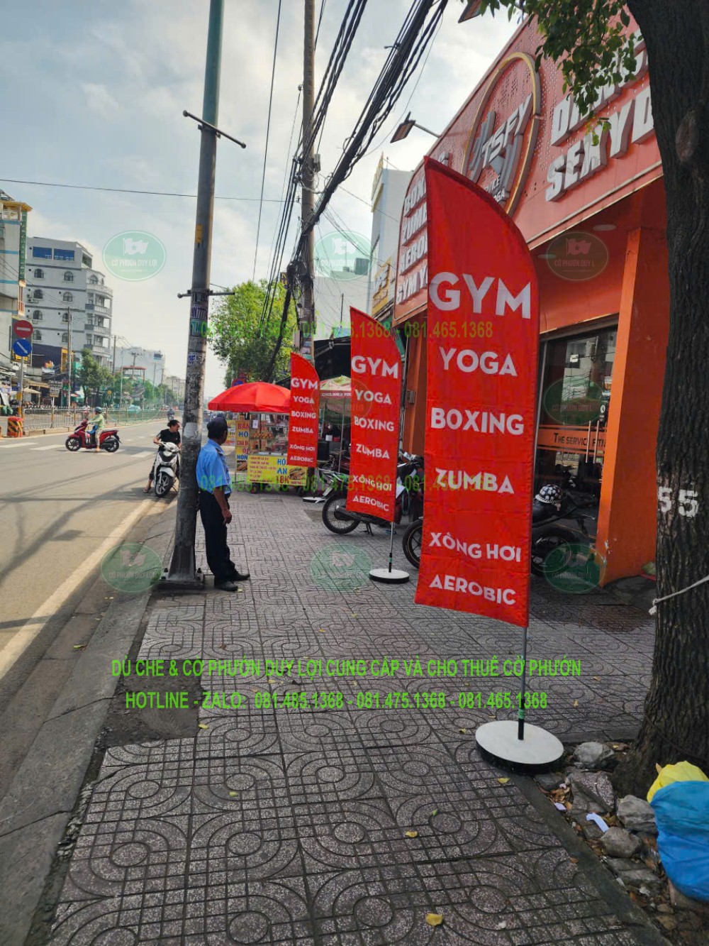 Cờ màu cam đỏ liệt kê GYM, YOGA, BOXING và ZUMBA trước cơ sở thể thao.