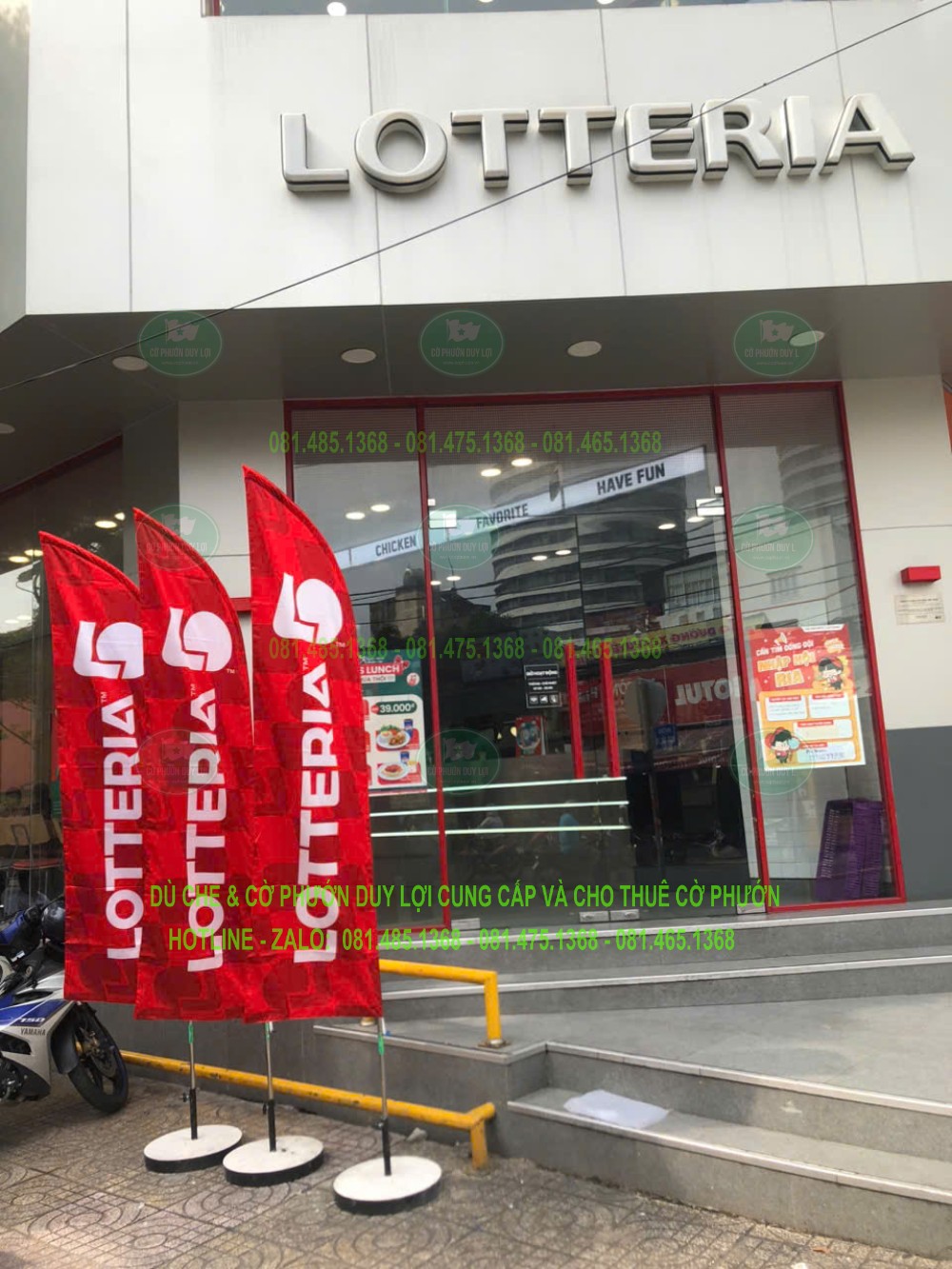 Ba cờ LOTTERIA màu đỏ bố trí thành cụm trước cửa nhà hàng, cạnh khu vực bậc lên xuống.