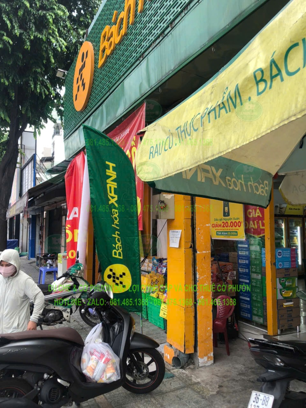 Cờ nhận diện đặt gần mặt tiền cửa hàng và khu vực xe, bên cạnh các vật phẩm giới thiệu khác.
