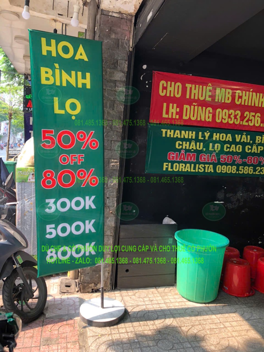 Cờ chữ nhật nền xanh đưa thông tin hoa, bình, lọ và các mức ưu đãi tại thời điểm chụp.