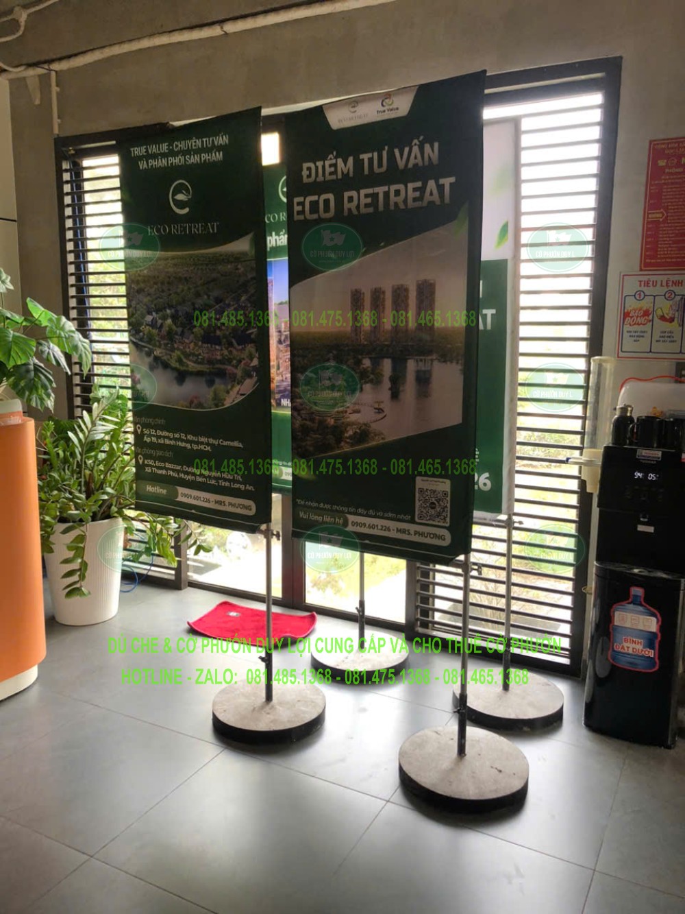 Hai cờ chữ nhật nền xanh được dựng trong không gian có mái che, cạnh khu vực tư vấn ECO RETREAT.
