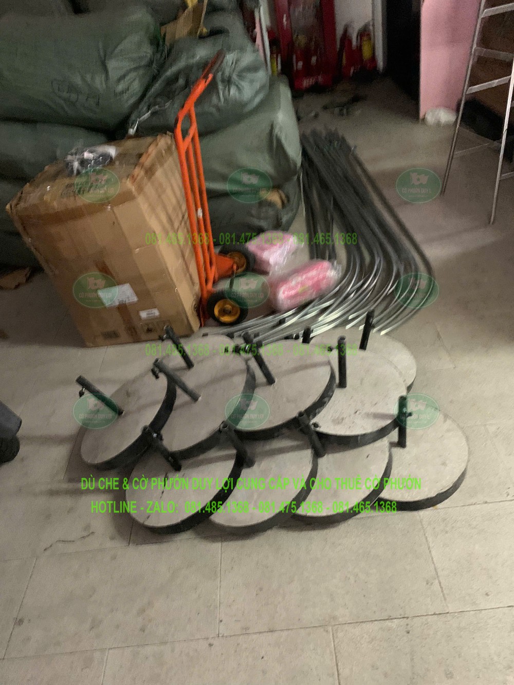 Các đế tròn và khung cờ được tập kết trong kho để chuẩn bị cho việc vận chuyển, lắp đặt.