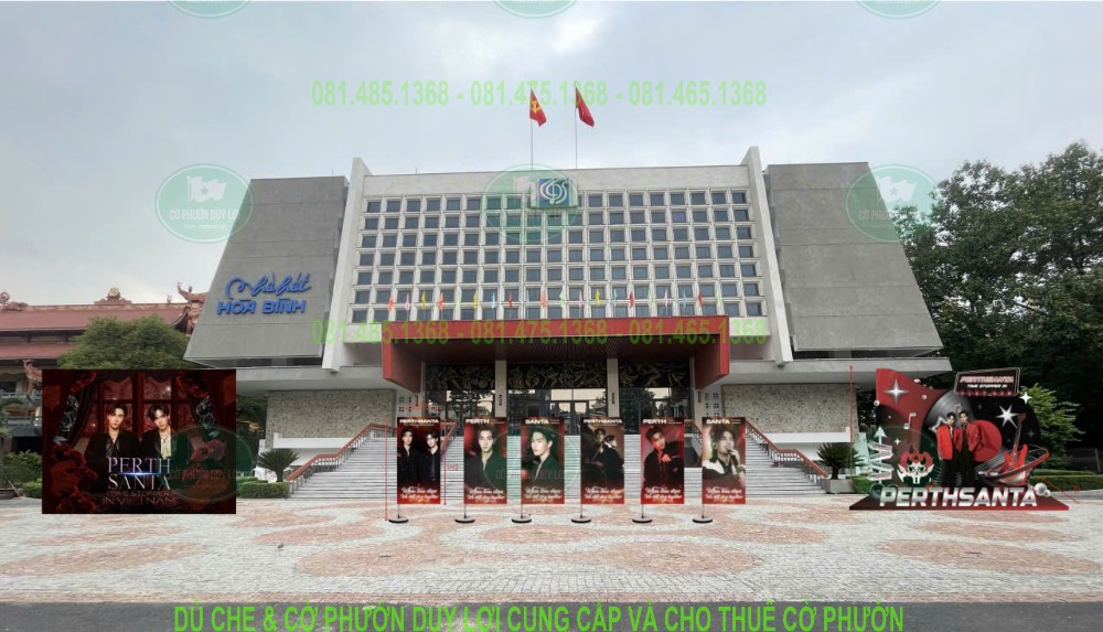 Toàn cảnh địa điểm có bảng chữ Nhà hát Hòa Bình, với các cờ sự kiện đặt ở khu vực phía trước.