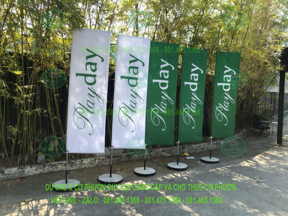 Năm cờ chữ nhật xanh và trắng mang chữ Playday, bố trí thành hàng với nội dung lớn trên vùng in thẳng.