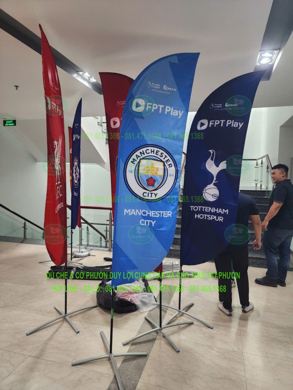 Các cờ FPT Play in nhận diện Manchester City và Tottenham Hotspur được dựng trong nhà bằng đế chân chữ X.