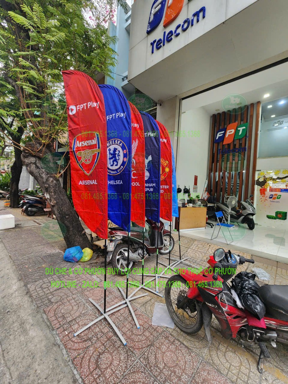 Cụm cờ FPT Play mang nhận diện câu lạc bộ bóng đá đặt trước cơ sở FPT Telecom, sử dụng đế chân chữ X.