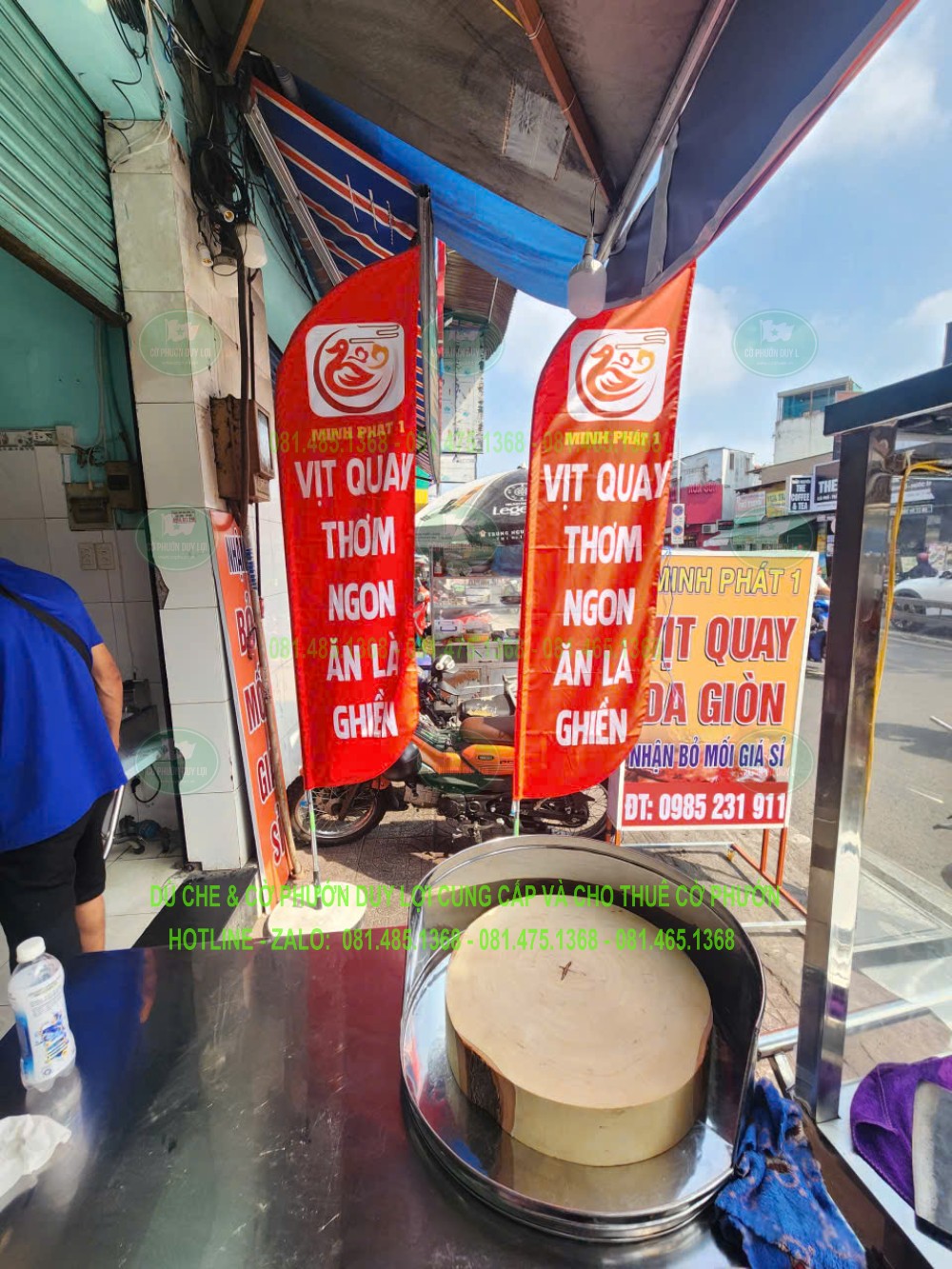 Hai cờ đỏ giới thiệu vịt quay và thông điệp về món ăn, đặt cạnh quầy bán hàng.