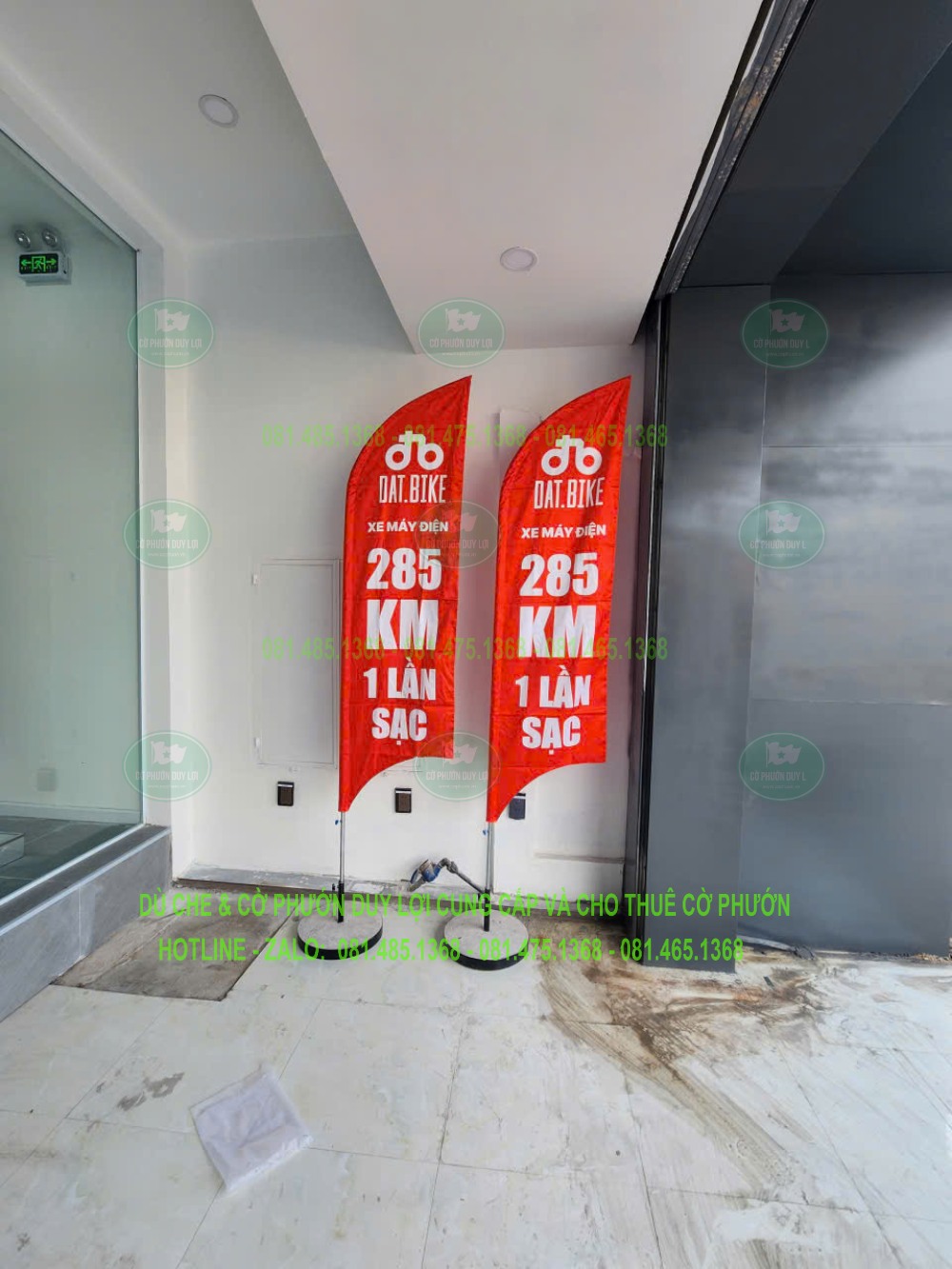 Hai cờ đỏ đặt trong nhà, hiển thị thông điệp 285 km một lần sạc trên lá quảng cáo.