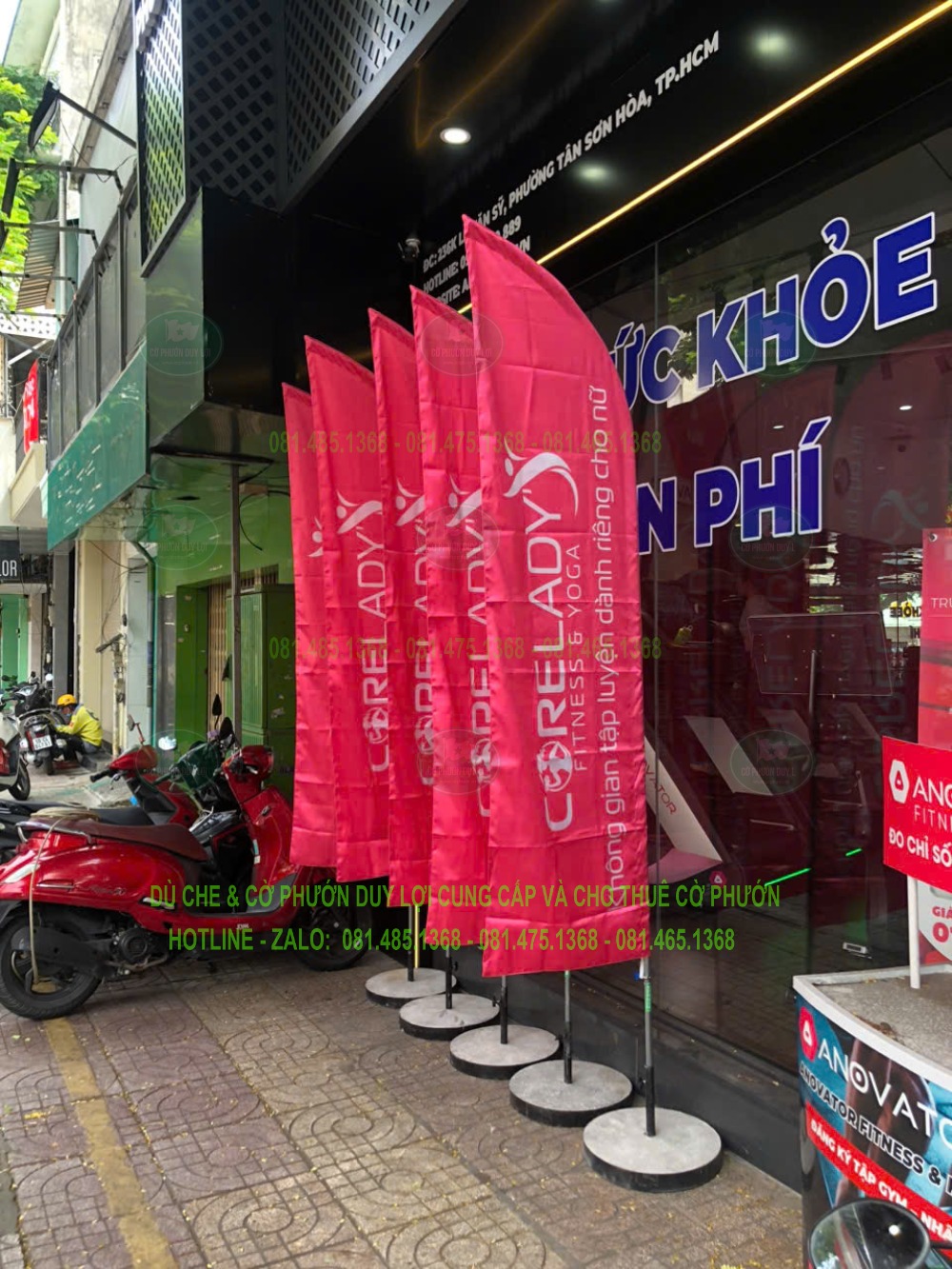Dãy cờ màu hồng đặt trên đế tròn trước mặt tiền ANOVATION Fitness & Recovery.