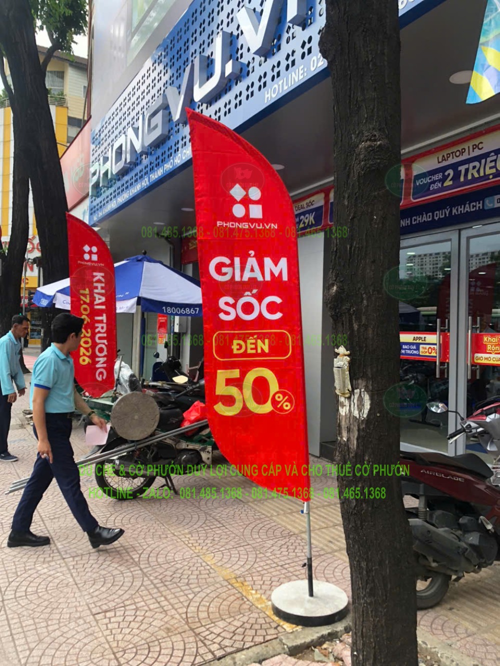 Cờ quảng cáo màu đỏ mang tên Phong Vũ và nội dung giảm giá được dựng trước mặt tiền cửa hàng.